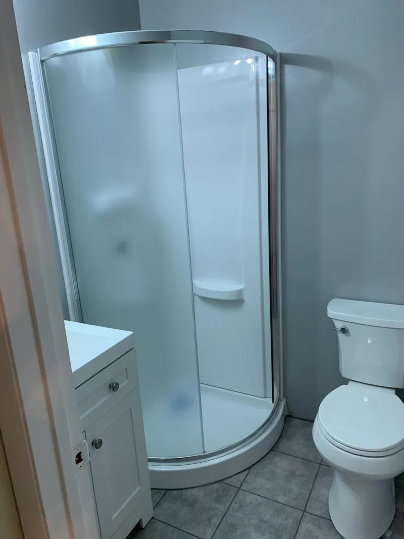 Complete bathroom remodel - new tiling, shower, cabinet, sink, and toilet.
